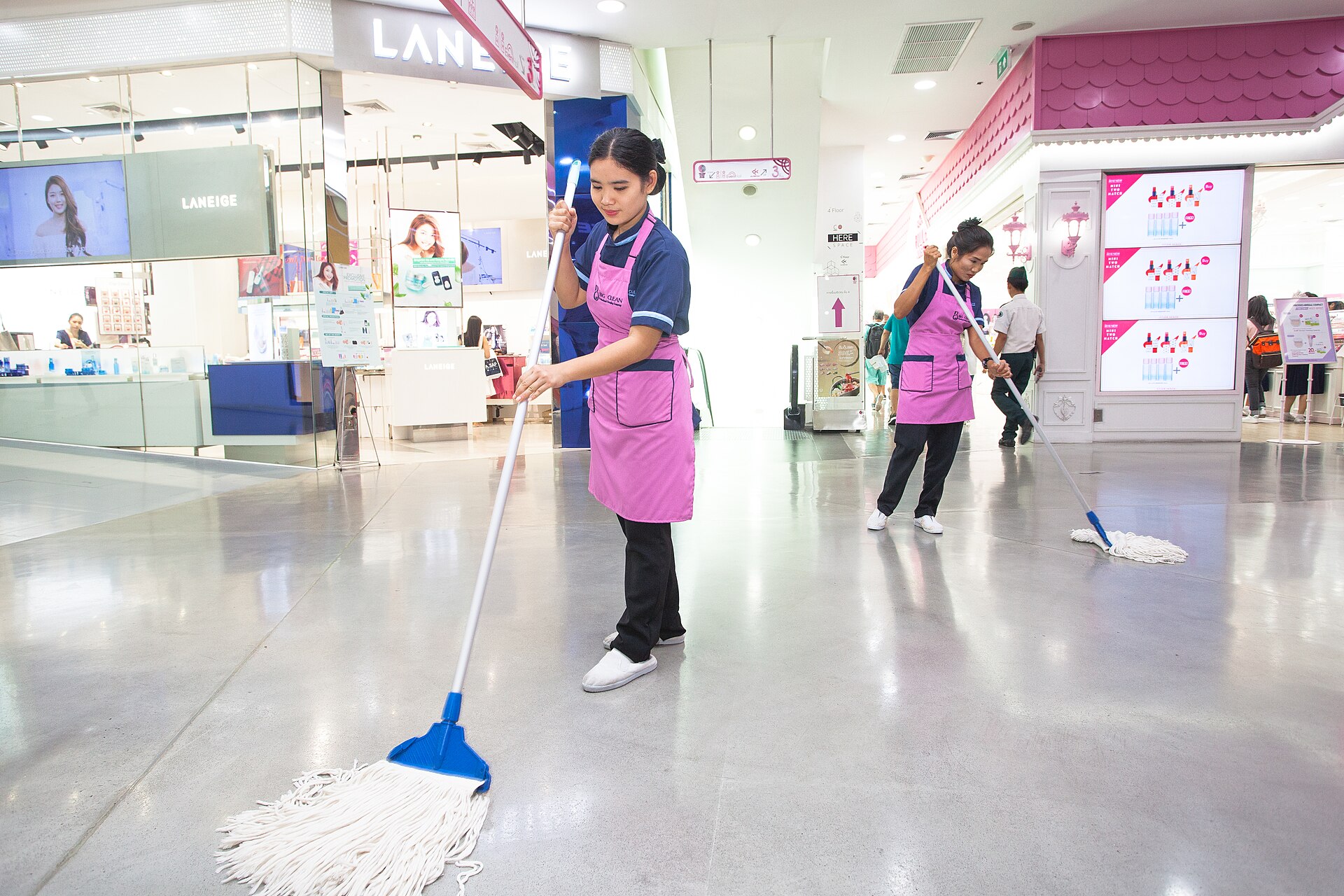 A cleaner mopping a polished floor